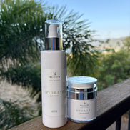 Hydrate Cleanser and Moisturiser on a timber railing with tropical foliage