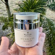 Hydrate Moisturiser 50 mL held in a hand outdoors