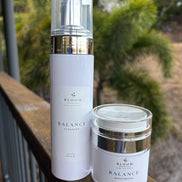 Balance Cleanser and Moisturiser on a timber railing with tropical foliage