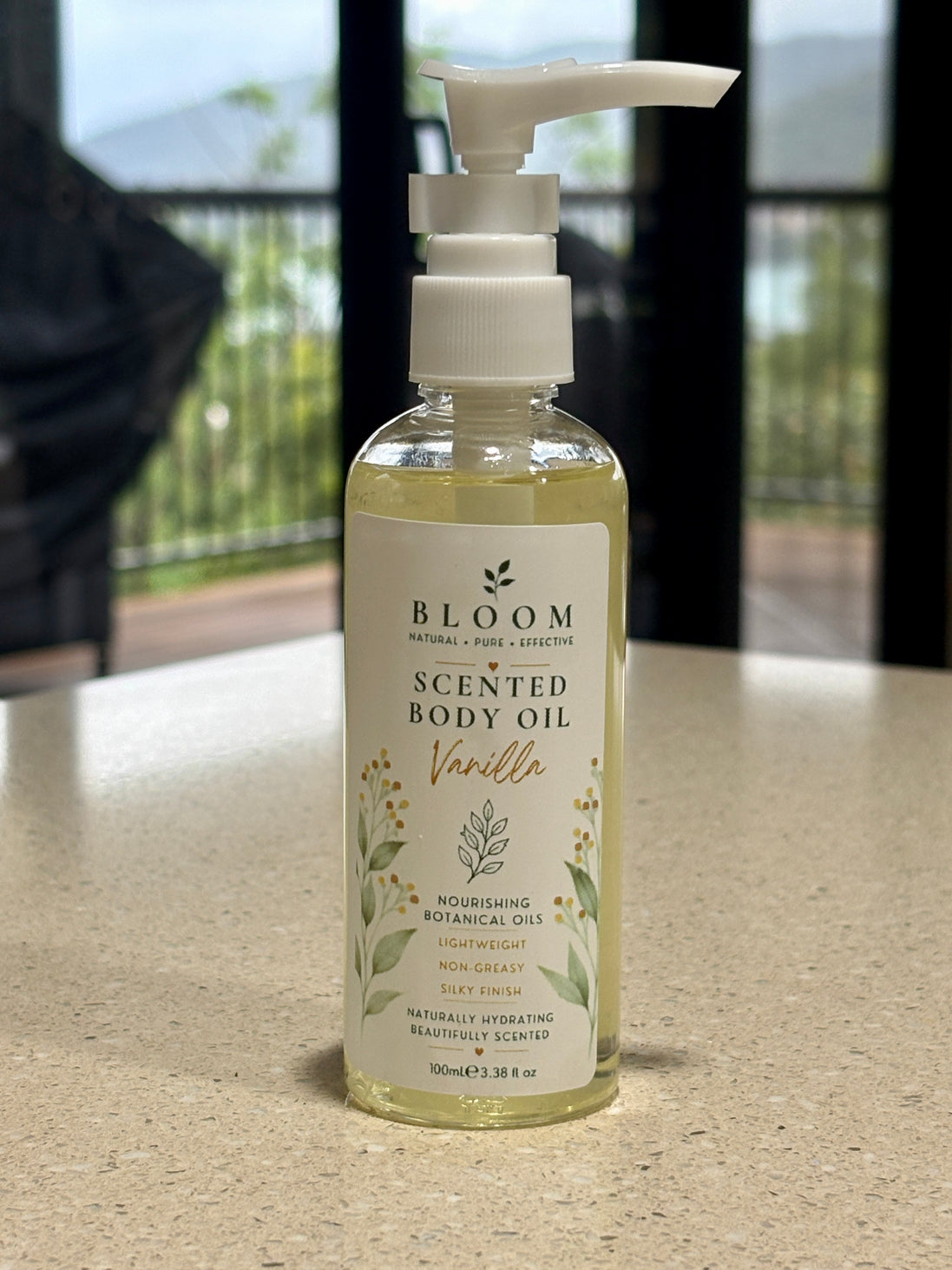 Vanilla Botanical Body Oil 100 mL with white pump and gold botanical label photographed on a countertop