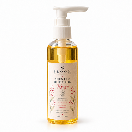 Rouge scented body oil 100 mL in a clear bottle with white pump and golden oil on a white background